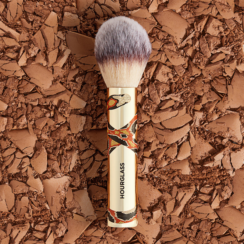 A limited-edition, travel size powder brush for on-the-go application, featuring exclusive snake artwork by London-based illustrator Katie Scott.