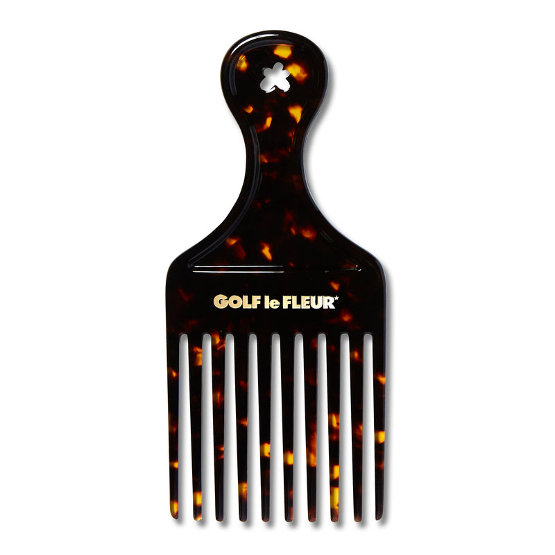 A tortoise-acetate hair pick comb with a gold foil-stamped logo.