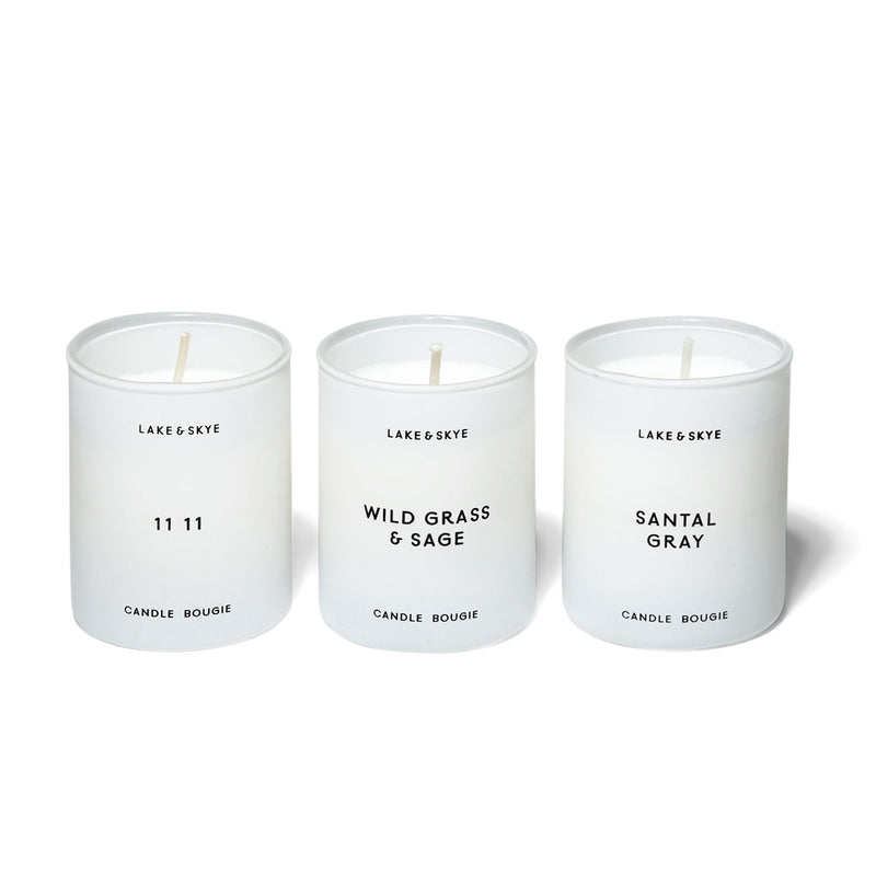 A trio of mini candles that include the 11 11 in notes of white ambers and musk, Santal Gray in notes of sandalwood and violet leaf, and Wild Grass & Sage in notes of lemon leaves and sage.